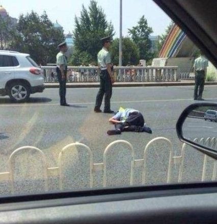 交警被撞出大概10米左右，趴在地上一動(dòng)不動(dòng)。